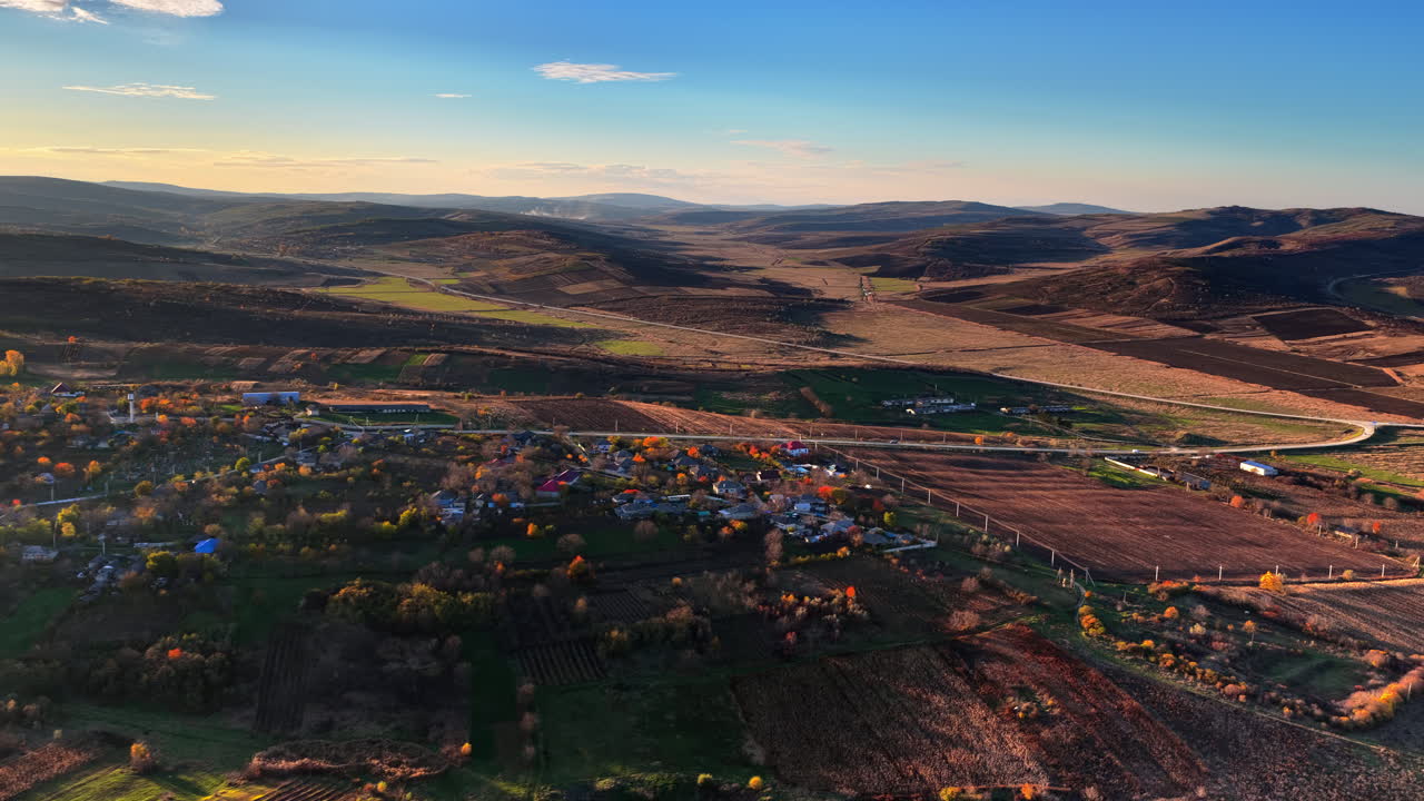 Aerial drone view of a Moldovan village surrounded by green fields and gentle hills