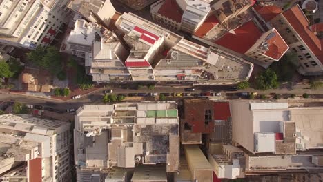 aerial drone top shot of rooftops urban center of athens small road downtown traffic capital of greece sunny day establishment generic shot shapes geometry small buildings