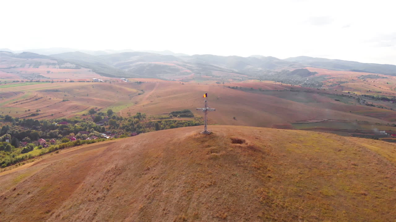 Aerial footage over Large Cross with Romania flag on High Hill and landscape at Summer