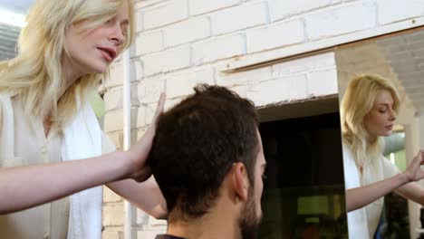 Man-getting-his-hair-trimmed-with-scissor