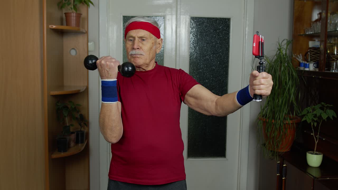 은 할아버지 남자가 집에서 덤벨, 훈련, 피트니스, 스포츠 활동으로 운동을 하고 있습니다.