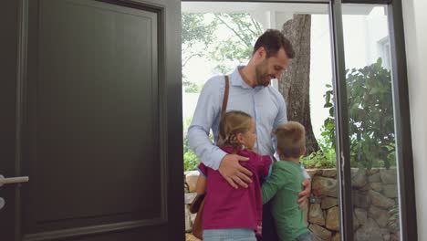 Father-embracing-his-children-at-door-in-a-comfortable-home-4k