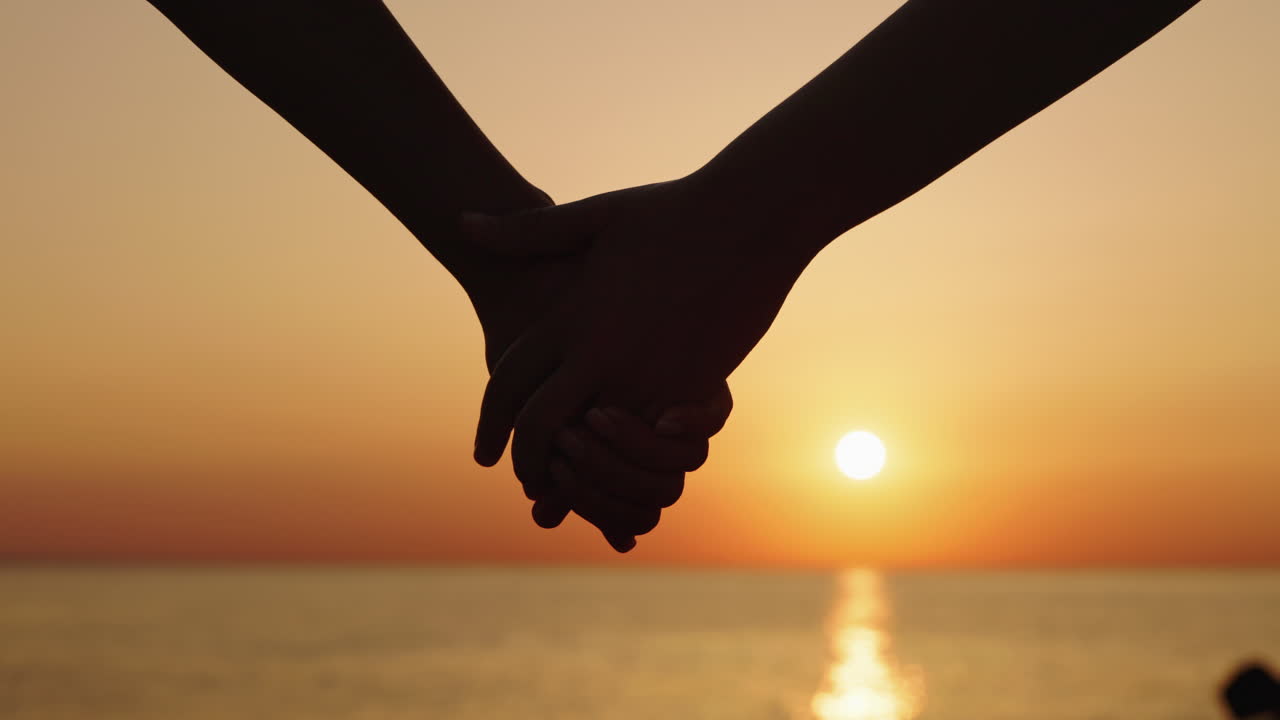 Silhouette of Hands Holding at Sunset