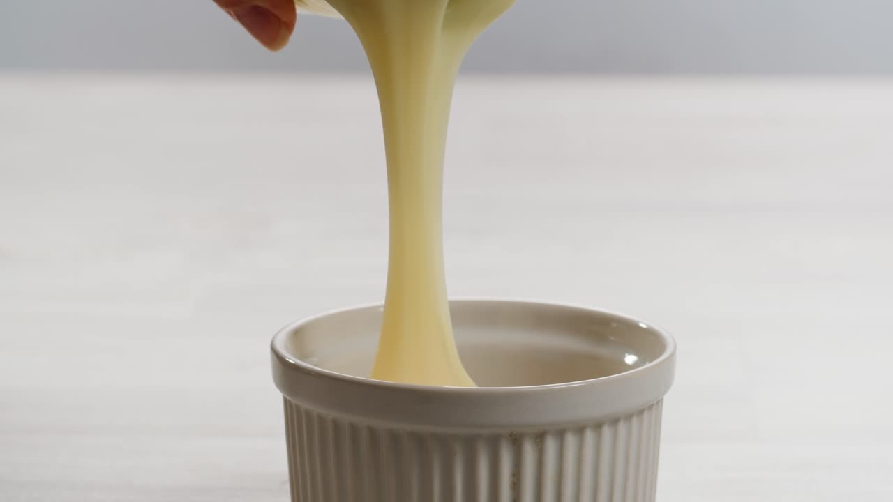 leche condensada con azúcar, abre una lata de un ingrediente cremoso, revelando con éxito su delicioso contenido dentro