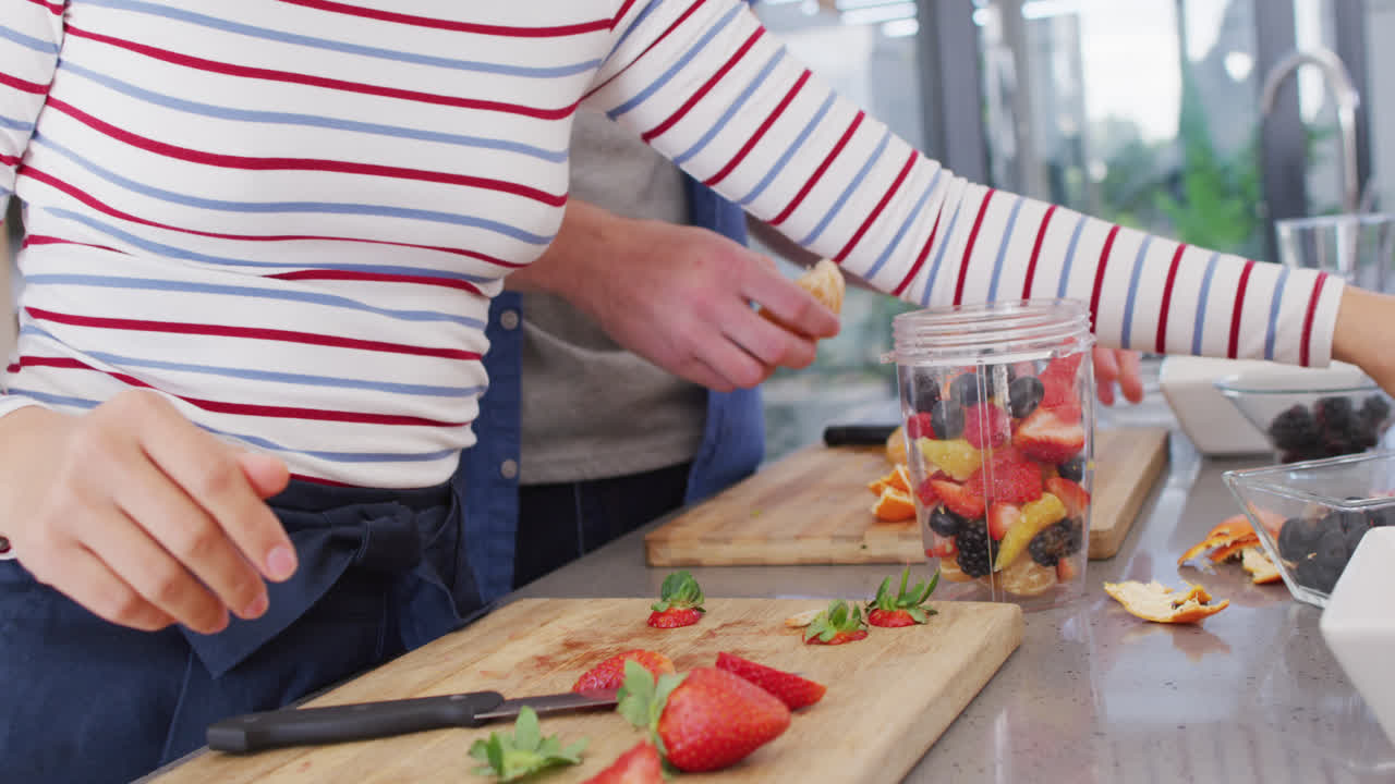 과일을 주스로 준비하는 다양한 커플의 중간 부분의 비디오