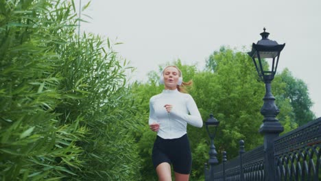 woman running in a park with headphones
