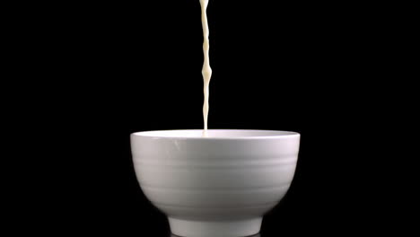 milk being poured into a bowl