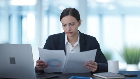 mujer de negocios india seria chequeando informes