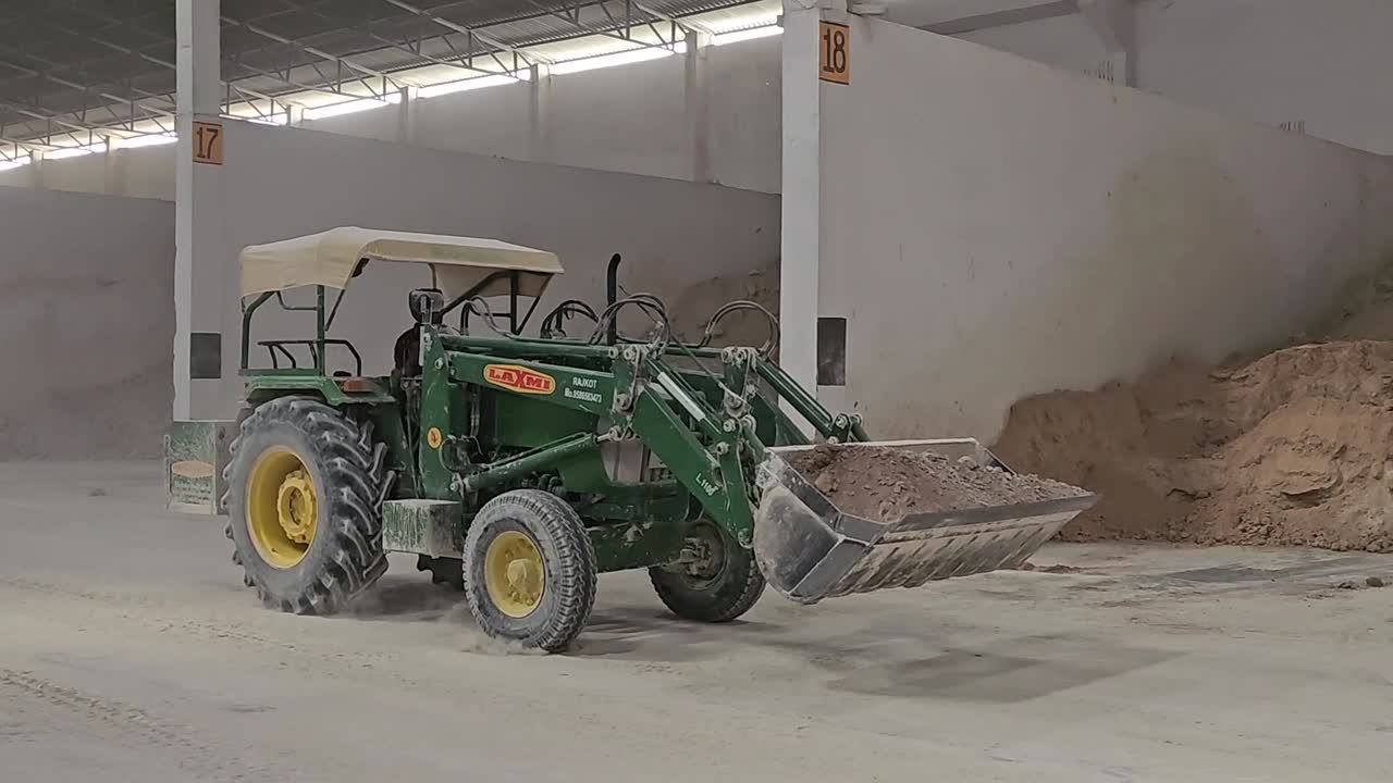 the raw materials of ceramic are going to the mixing by a tractor with heavy driver