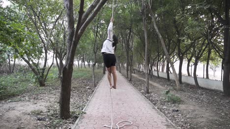 una gimnasta deportiva realiza ejercicios con una cuerda en ropa deportiva