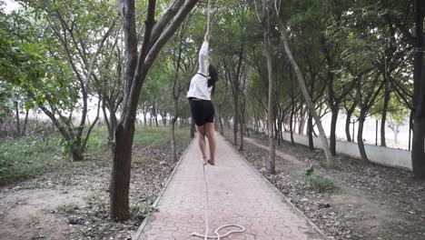 a sporty gymnast performs exercises with a rope in sportswear