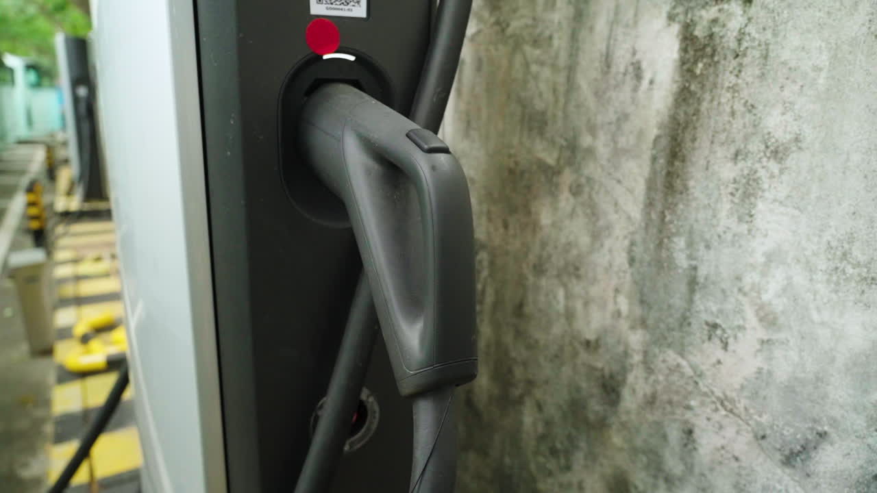 中国の深圳にあるBYD充電ステーションに接続された、高出力の急速充電ケーブル。クリーンな公共交通機関と持続可能な都市のモビリティを支える充電インフラのクローズアップ。