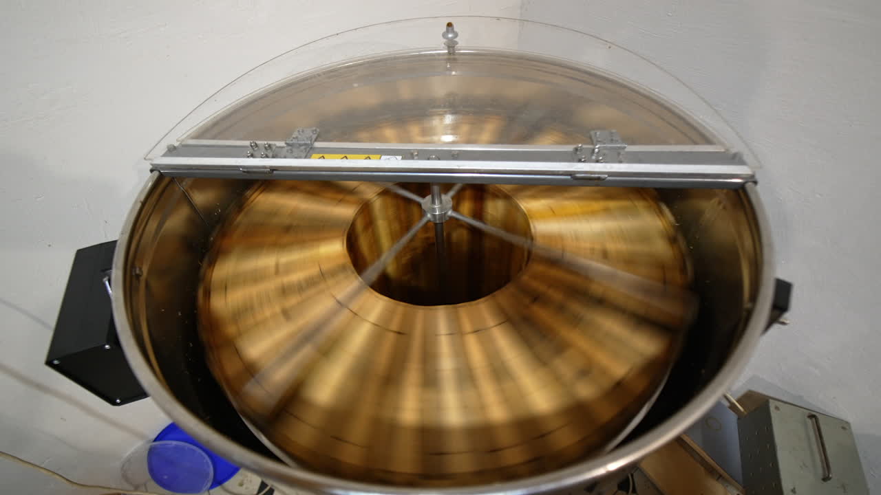 Centrifuge machine rotating honey frames to extract honey from cells. Beekeeper's equipment for collecting honey harvest. Top view.