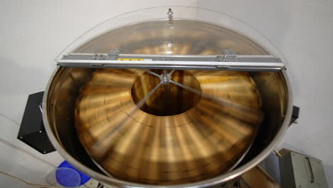 Centrifuge machine rotating honey frames to extract honey from cells. Beekeeper's equipment for collecting honey harvest. Top view.