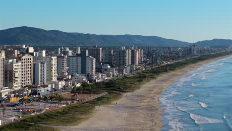 panning aerial movement from the coastal side with high-rise apartments of navegantes tourist city, santa catarina, brazil