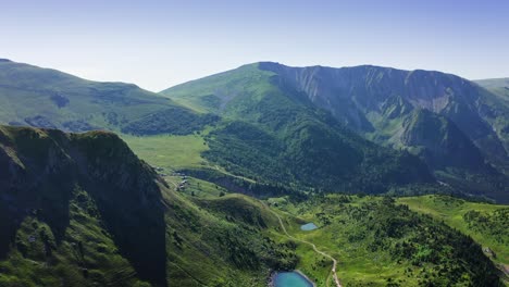 aerial view of mountain plateau with lakes among green meadows in sunlight