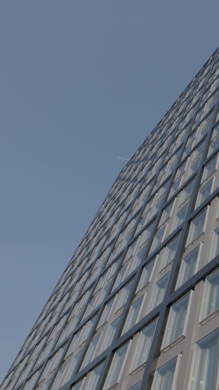 Vista exterior de um edifício moderno com o céu, mostrando a arquitetura urbana