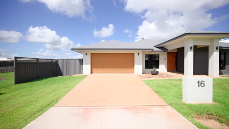 dolly to orange garage door on white black modern large display home house home frontage