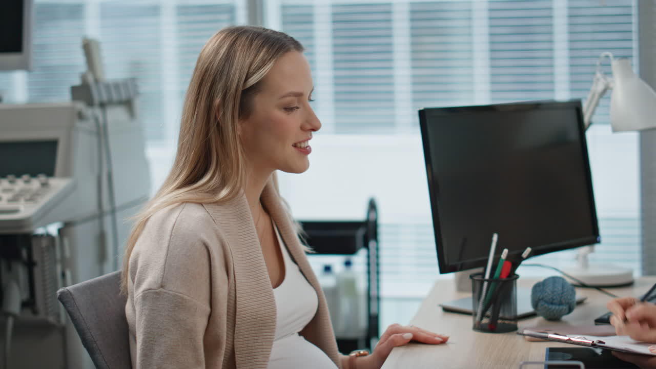 Pregnant woman visiting checkup in clinic. Closeup mother hands touching belly