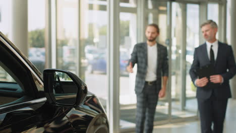 car salesman discussing deal with client in showroom