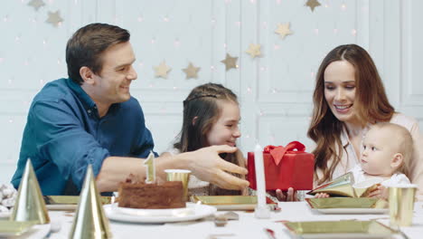 familia feliz presentando regalo al niño de cumpleaños en una casa de lujo