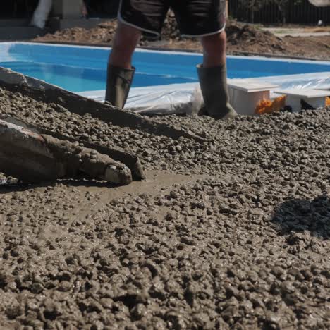 concrete flows down the gutters where workers make paving 4