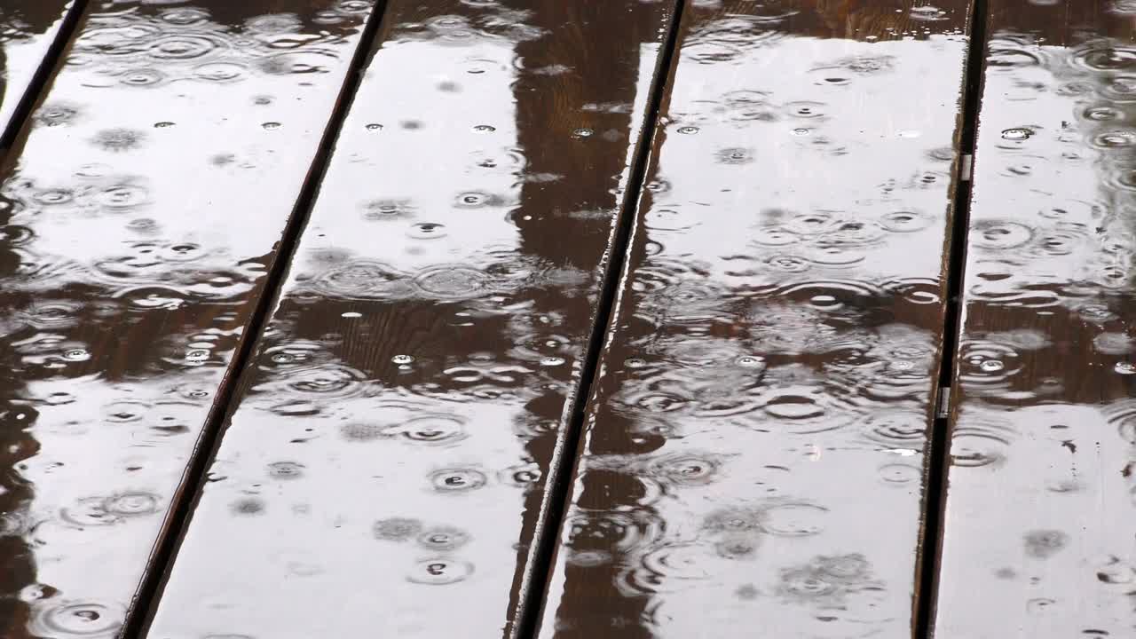 Rain drops falling on the porch of the house.