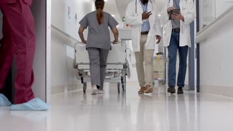 Diverse-male-nurse-and-doctor-with-tablet-walking-in-slow-motion,-unaltered