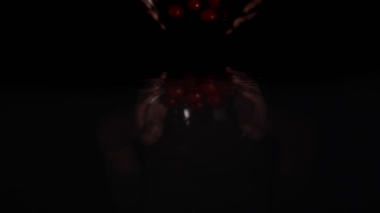 ampliar el video macro de los tomates en la superficie negra