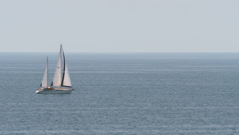 yacht with sails in quiet blue sea