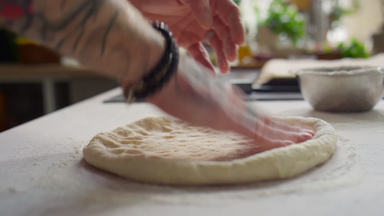 Mani che stendono l'impasto per la pizza