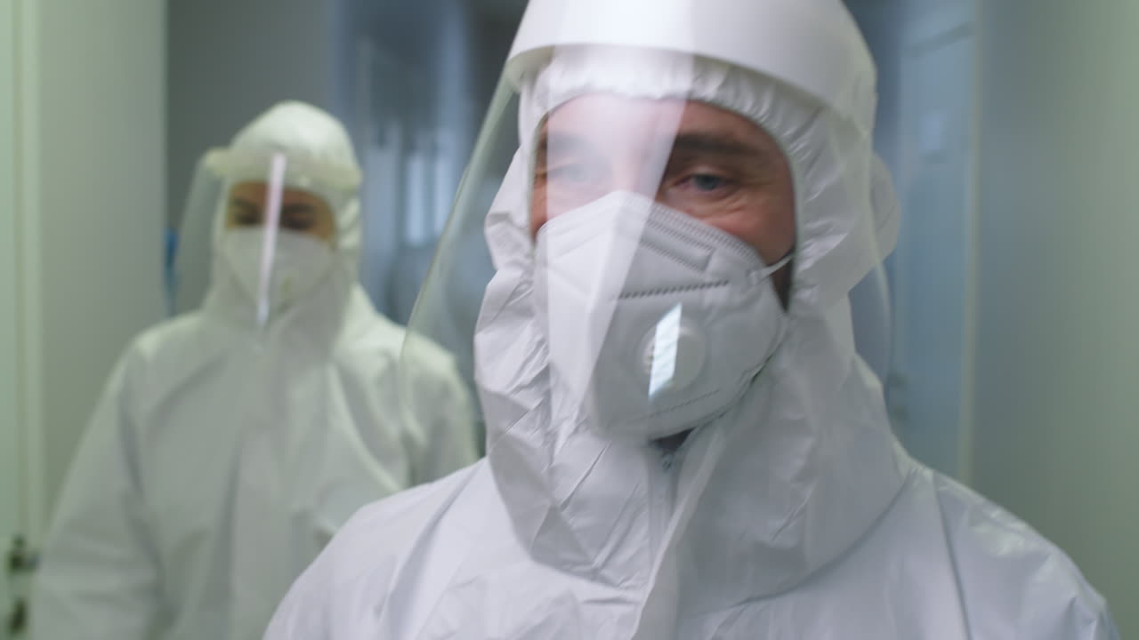 médico de sexo masculino en uniforme de protección pasando por el hospital