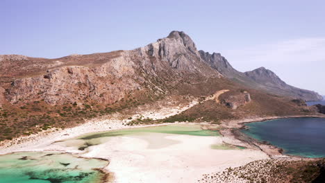 aerial dolly shot of balos beach moving across the lagoon towards the mountains on beautiful sunny day