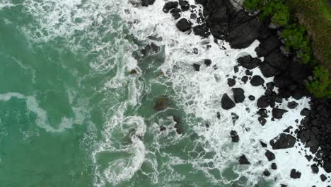 Playa,-Océano-Azul,-Olas-Y-Costa-Rocosa-Negra---De-Arriba-Hacia-Abajo---Drone-Aéreo