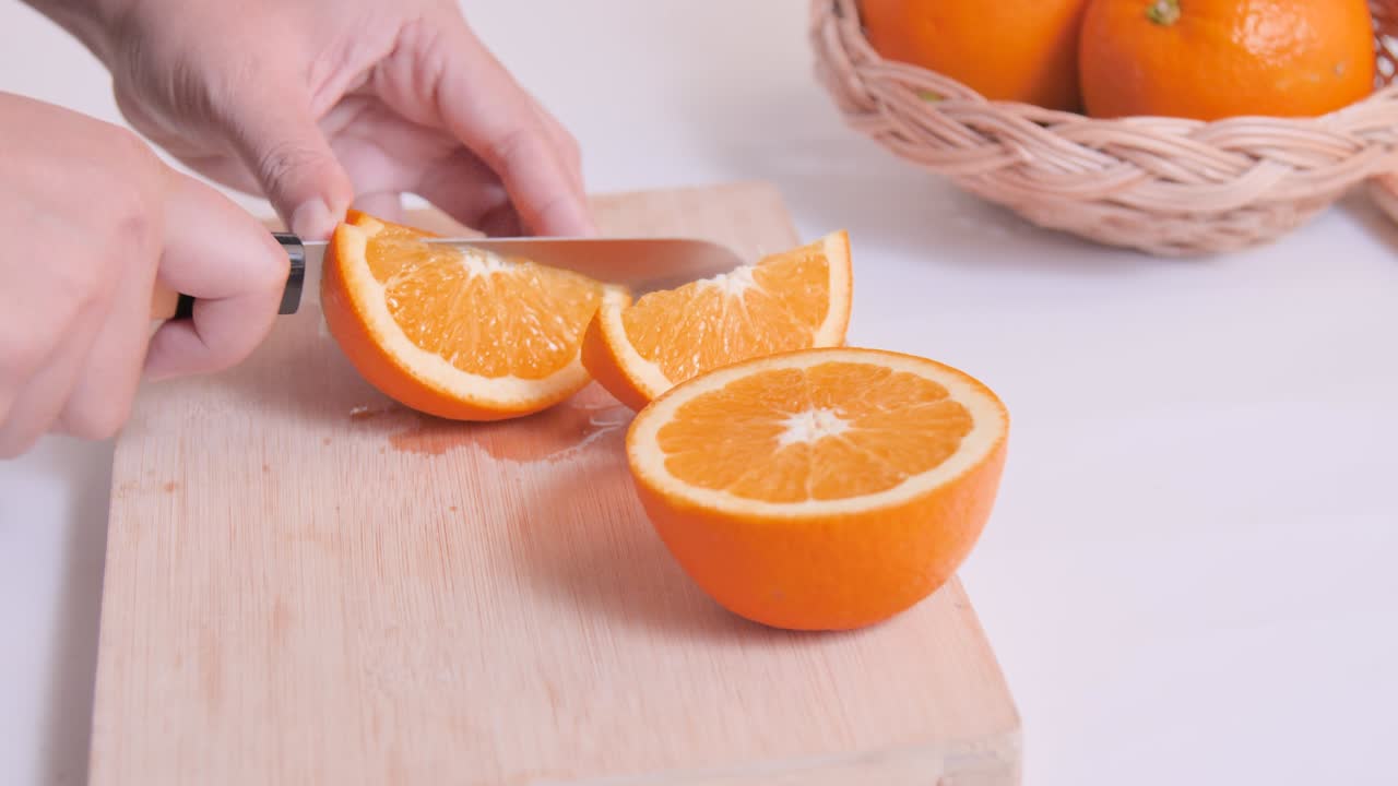 un primer plano de una naranja en la tabla de cortar en la cocina.