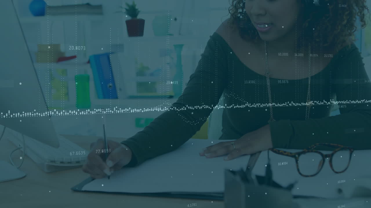woman sketching digital designs on tablet in modern office, showing animated tech icons floating