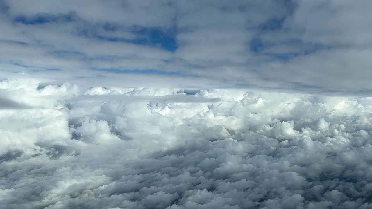 대낮에 구름층 사이를 날아다니는 조종석의 공중 전망