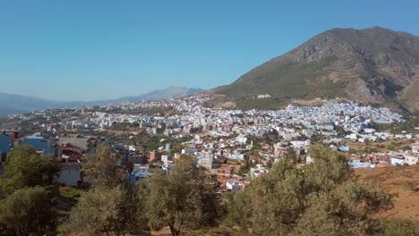 chefchaouen, the blue perl traditional city view from a distance, surrounded by the riff mountains on a clear sunny day in morocco