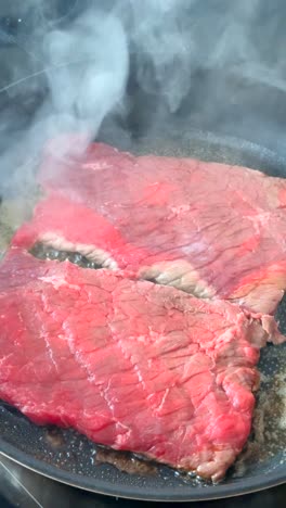searing raw meat in a pan