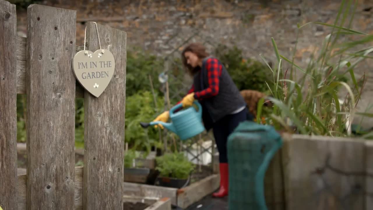 젊은 부부가 정원 가꾸고 있습니다.