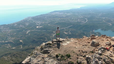 toma aérea estática de un turista masculino desde atrás disfrutando de la vista de marbella desde lo alto de la concha en españa