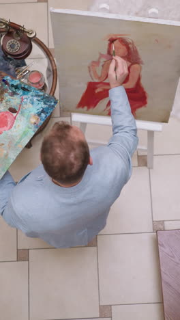 designer draws woman facial features in hall. art creator makes small strokes on canvas imagining lady portrait in studio. skilled artist enjoys job