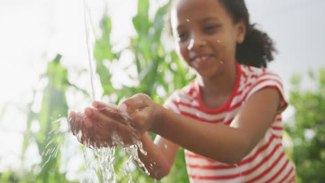 african american girl washing her hands outside