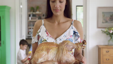 woman holding tray with roasted chicken at home 4k