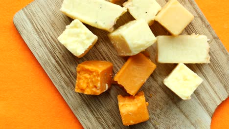 cubos de queso variados en una tabla de madera