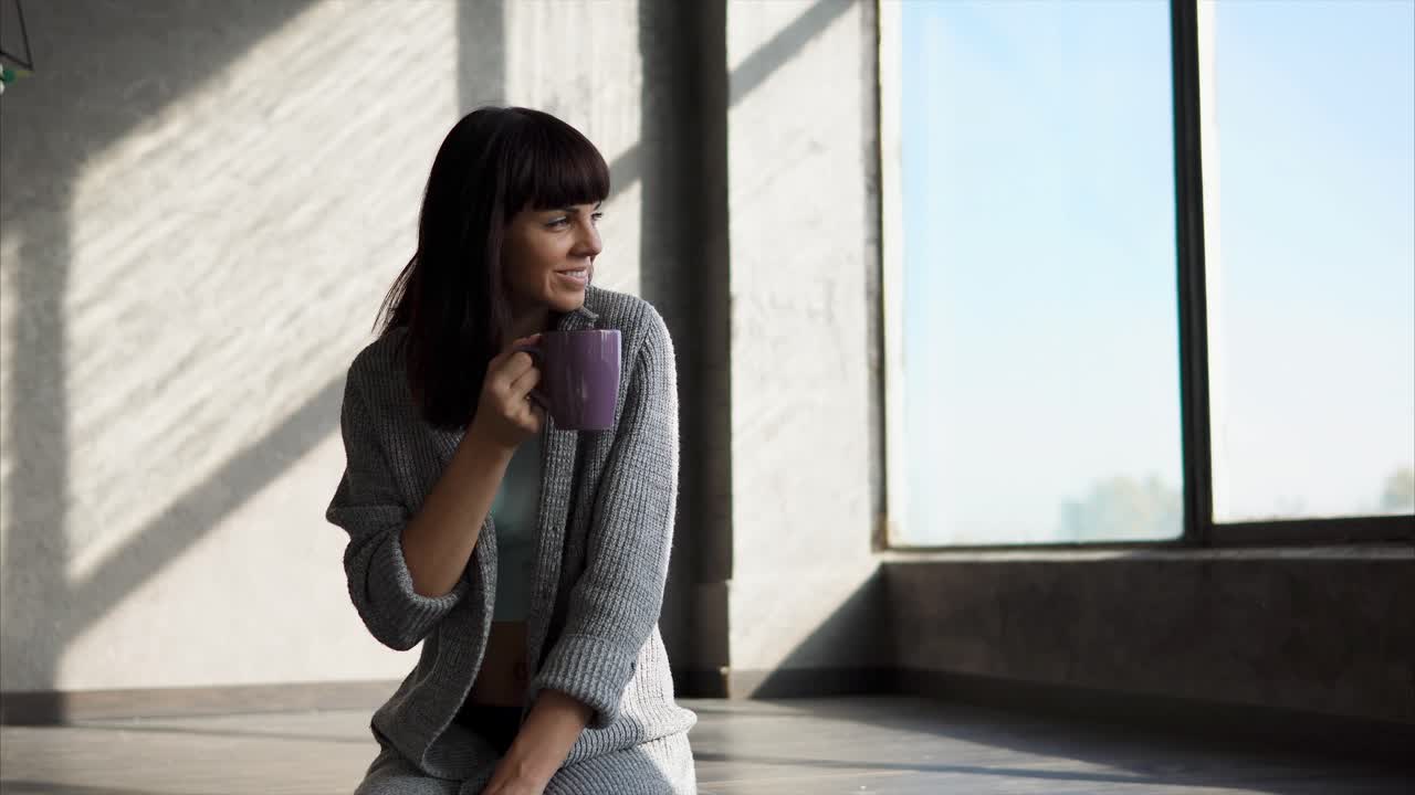 창문 에서 커피를 마시고 있는 여자