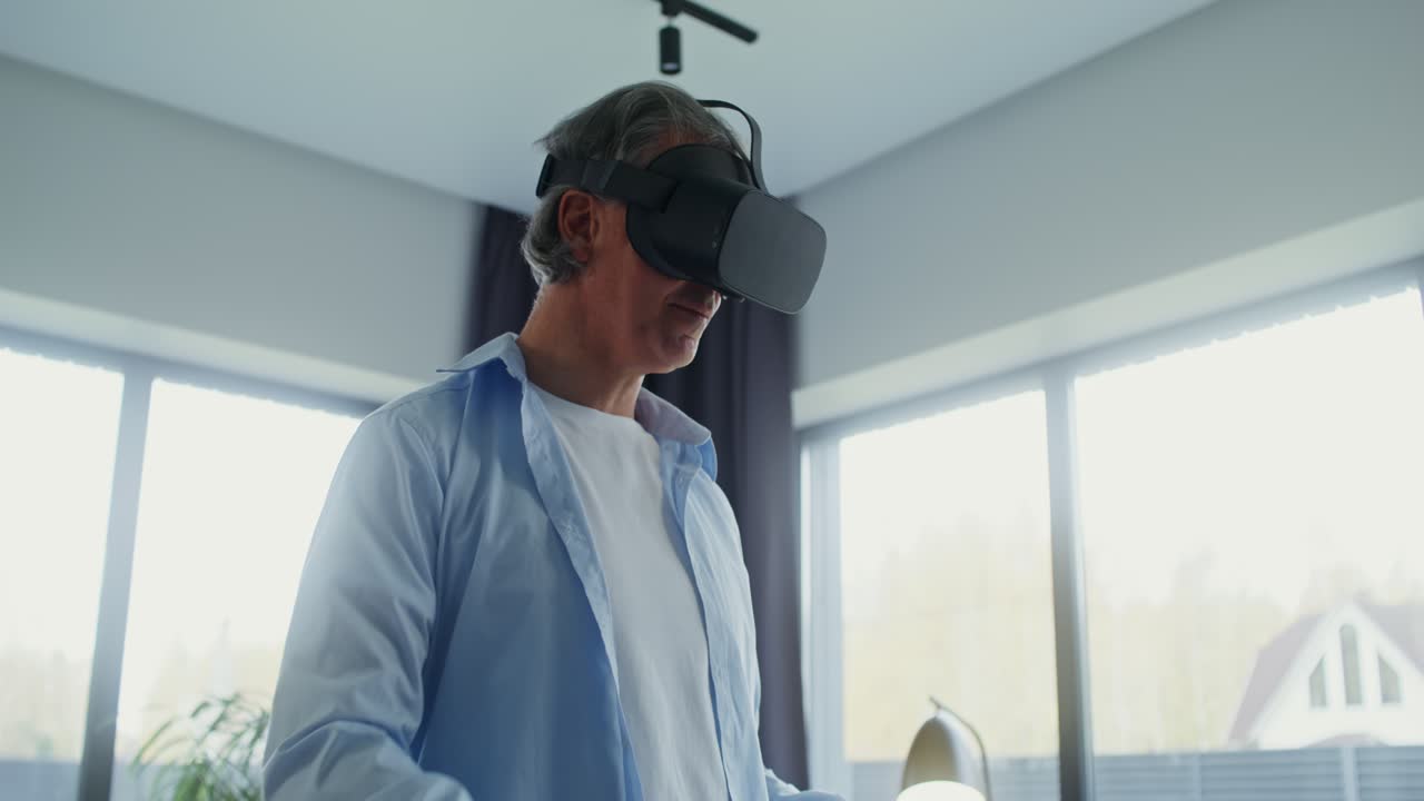 Mature man playing VR game with headset and controller