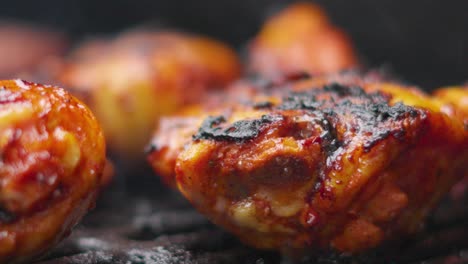 macro close up of marinated chicken thighs cooking on smoking bbq in slow motion 4k