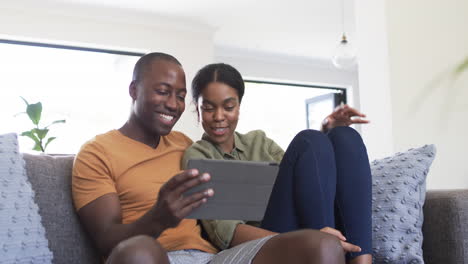 Una-Joven-Pareja-Afroamericana-Disfruta-De-Una-Tableta-Juntos-En-Casa-En-El-Sofá