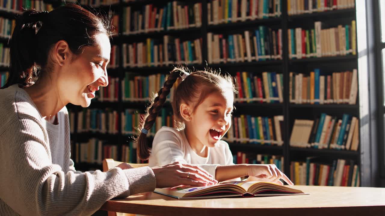 A warm, side-angle video of a woman and child reading in a sunlit library, capturing a cozy
